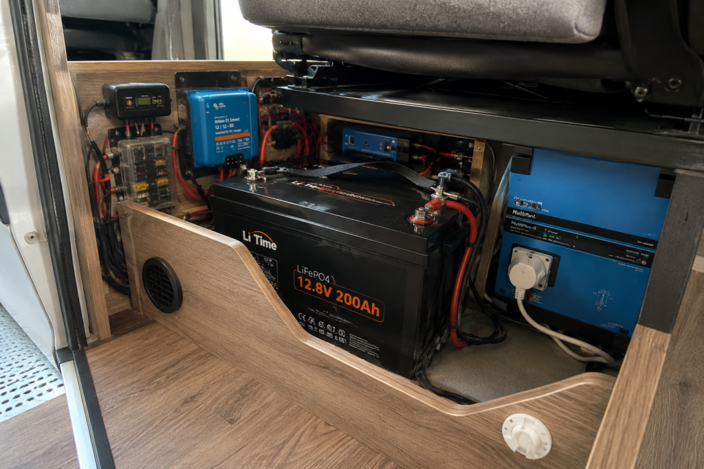 Instalación eléctrica de una camper con batería LiFePO₄, booster, inversor y protecciones bajo el asiento.