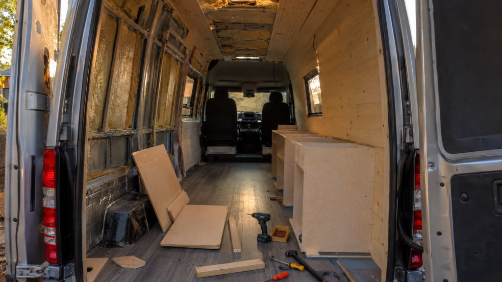 Interior de una furgoneta a medio camperizar con muebles y herramientas