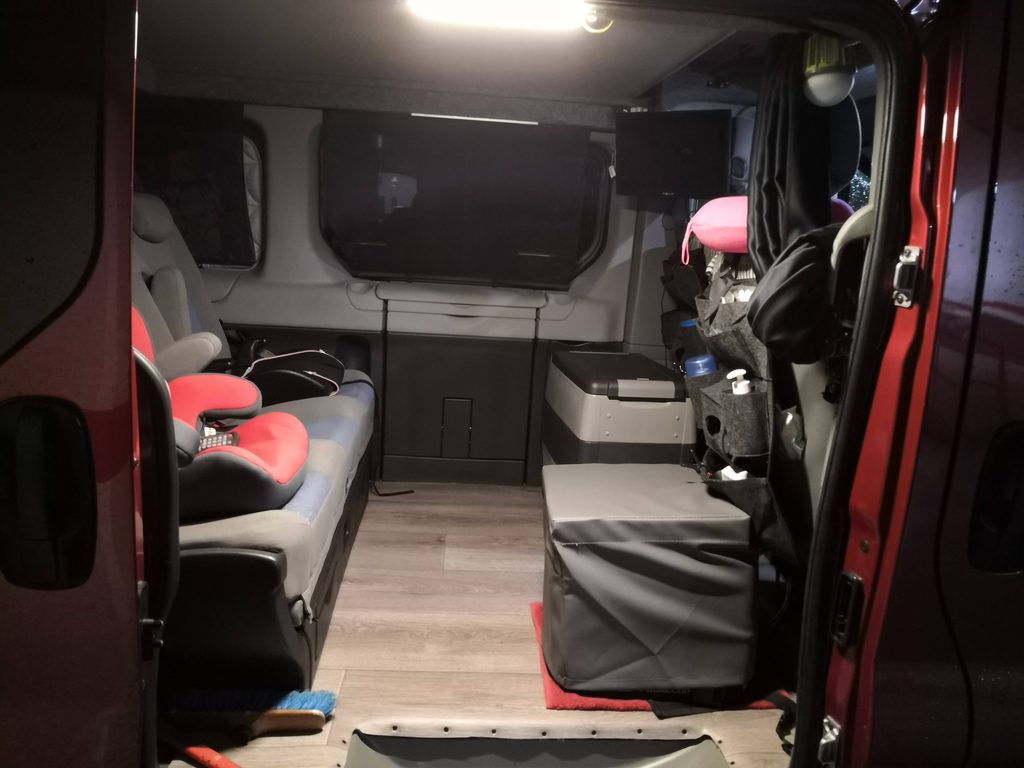 Interior de nuestra Renault Trafic camperizada con el baño químico guardado en su funda
