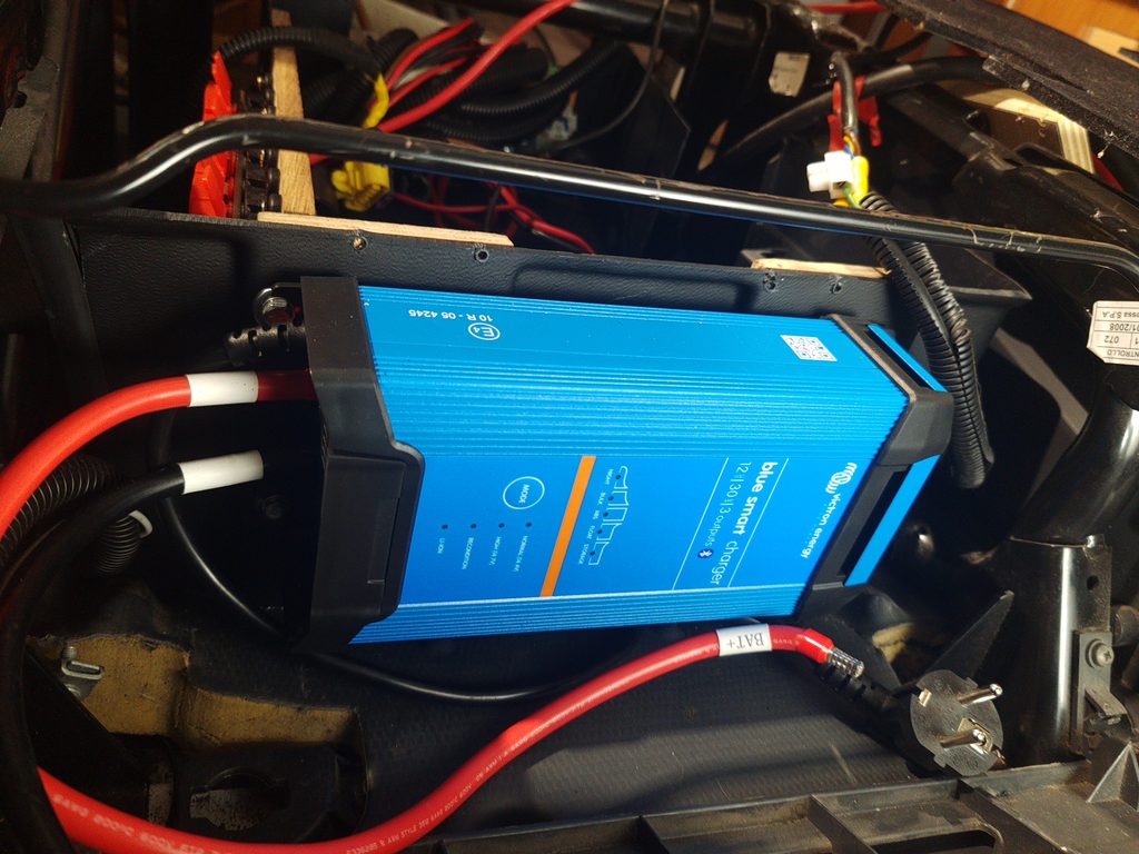 Cargador Victron Blue Smart IP22 de 30 A instalado bajo el asiento del copiloto de la autocaravana.
